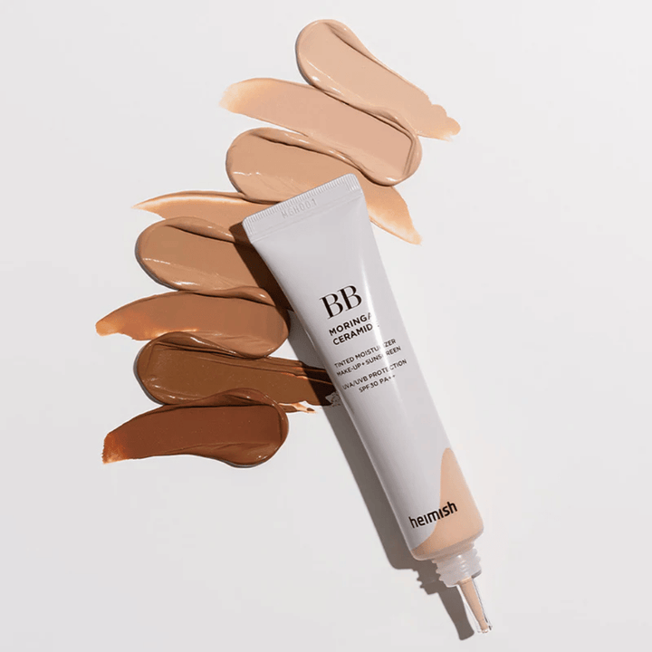 Heimish Moringa Ceramide BB Cream useiden eri ihonsävyisten sävynäytteiden ympäröimänä. Kuva esittelee tuotteen laajan värivalikoiman ja kermaisen koostumuksen, joka antaa luonnollisen peittävyyden ja tasaisen ihonsävyn.