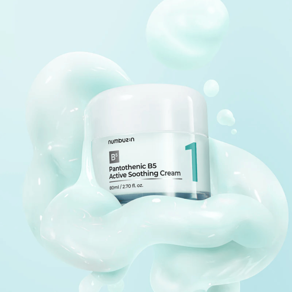 Numbuzin No.1 Pantothenic B5 Active Soothing Cream 80 ml vaaleanvihreässä purkissa, jossa on valkoinen kansi, ympäröitynä pehmeillä vaaleanvihreän kermaisen tekstuurin aalloilla vaaleansinisellä taustalla.