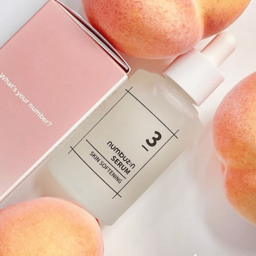 Pullo numbus:in No.3 Skin Softening Serum ympäröitynä persikoilla ja vaaleanpunaisella laatikolla, jossa lukee "What's your number?".