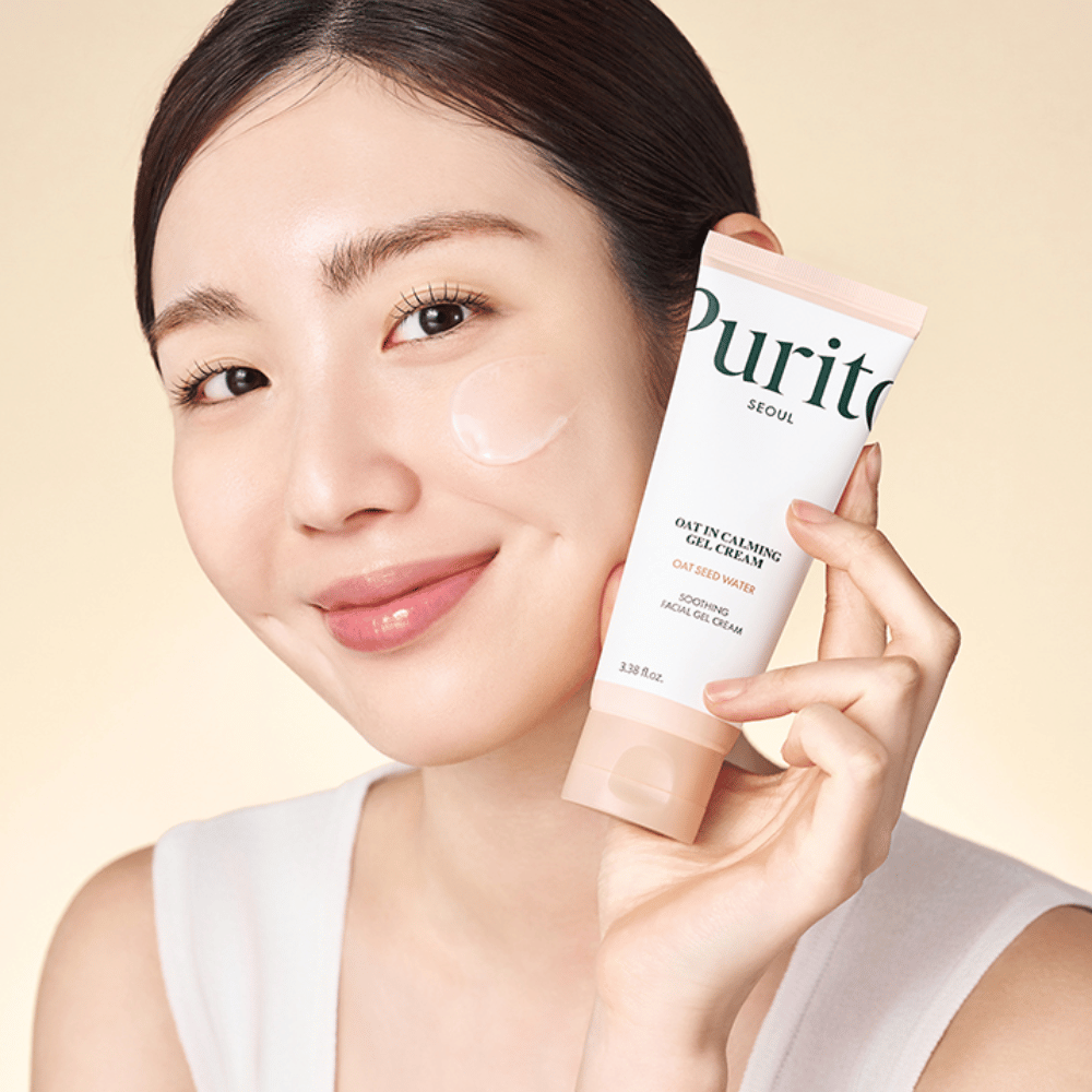 Nainen levittää Purito Oat-In Calming Gel Cream kasvoilleen. Mieto ja kosteuttava geelivoide herkälle ja ärtyneelle iholle.