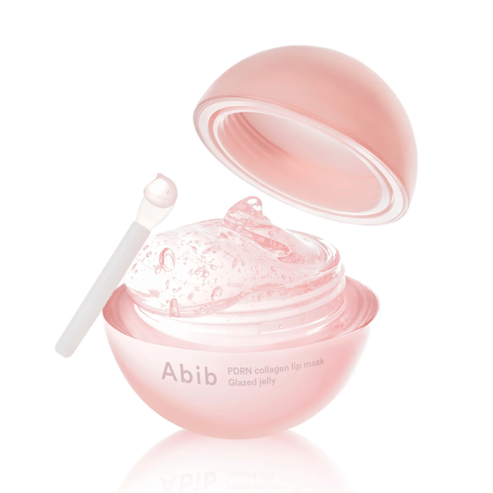 Vaaleanpunainen pyöreä purkki Abib PDRN Collagen Lip Mask Glazed Jelly, avattu kansi kallistettuna taaksepäin. Läpinäkyvä geeli, jossa on ilmakuplia, näkyy purkissa yhdessä pienen lastan kanssa.