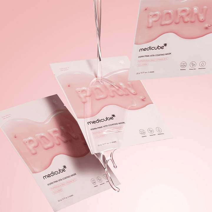 Medicube PDRN Pink Vita Coating Mask – tre rosa sheet mask-förpackningar med flytande essence, mot en mjuk rosa bakgrund.