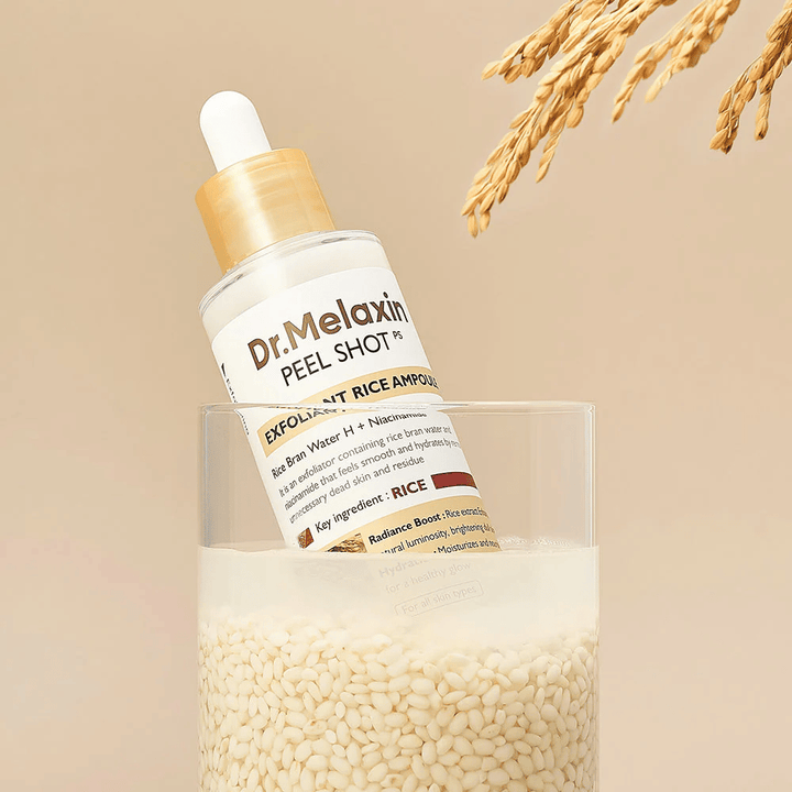 Dr.Melaxin Peel Shot Exfoliant Rice Ampoule sijoitettuna lasiin riisin kanssa, kuvastaa riisiuutteen hehkua antavia ja kosteuttavia ominaisuuksia korealaisessa ihonhoidossa.