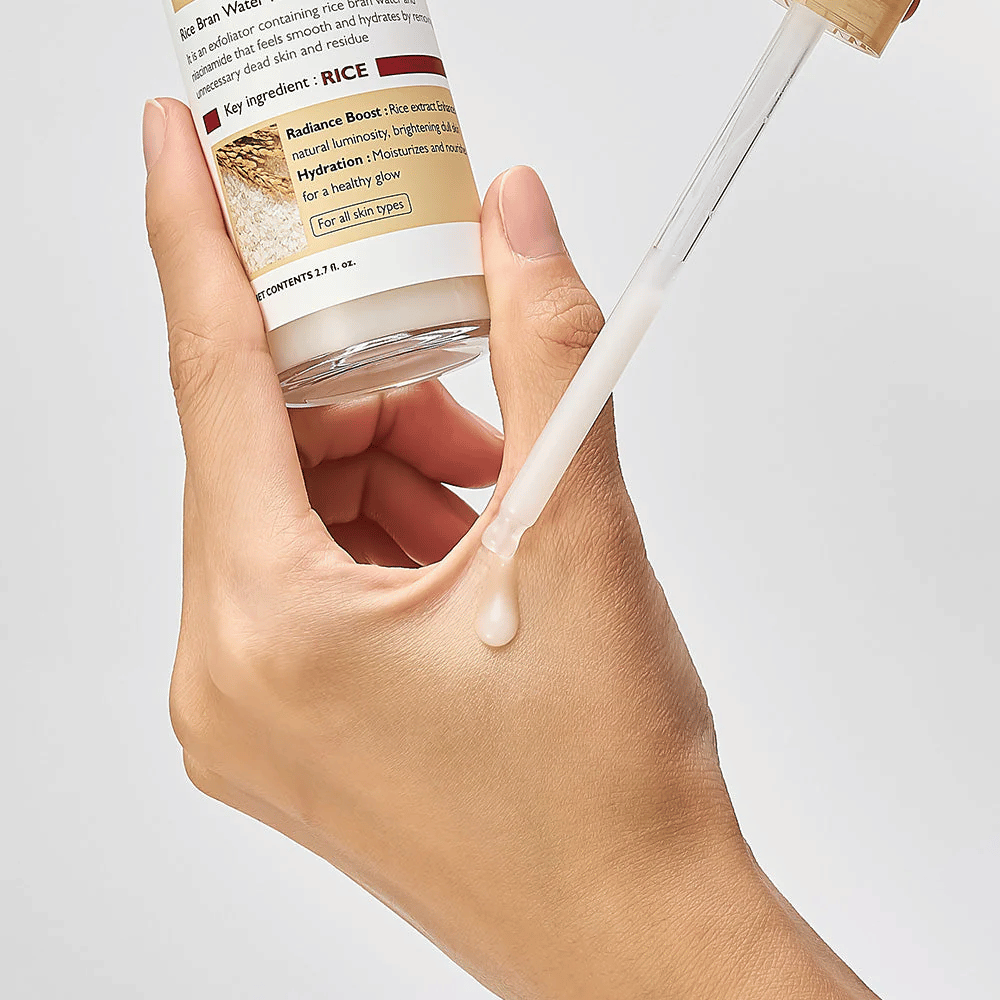 Lähikuva Dr.Melaxin Peel Shot Rice Ampoule -ampullista pipetillä kädelle levitettynä, helposti levittyvä kuoriva ampulli, joka imeytyy nopeasti ja antaa kosteutetun, sileän ihon.