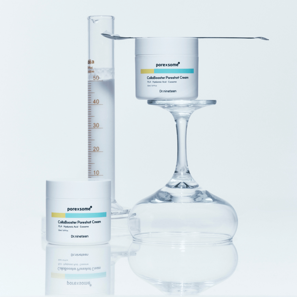 Kaksi purkkia Dr.nineteen Porexsome CollaBooster Poreshot Cream sijoitettuna lasin ja mittalasin viereen. Minimalistinen muotoilu, joka viestii tieteellisestä tarkkuudesta.