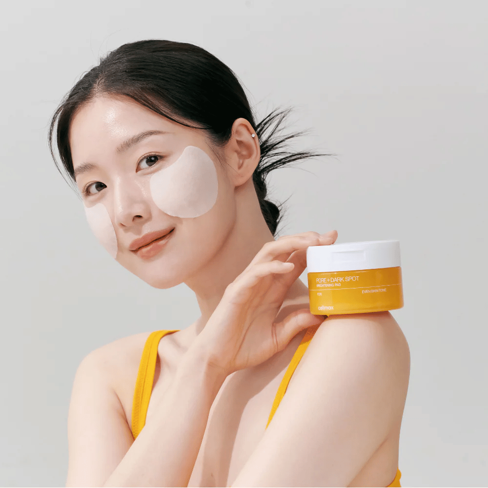 Nainen levittää Celimax Pore + Dark Spot Brightening Pad – korealaiset tyynyt, jotka tasoittavat ihon sävyä ja vähentävät huokosia ja pigmenttiläiskiä.