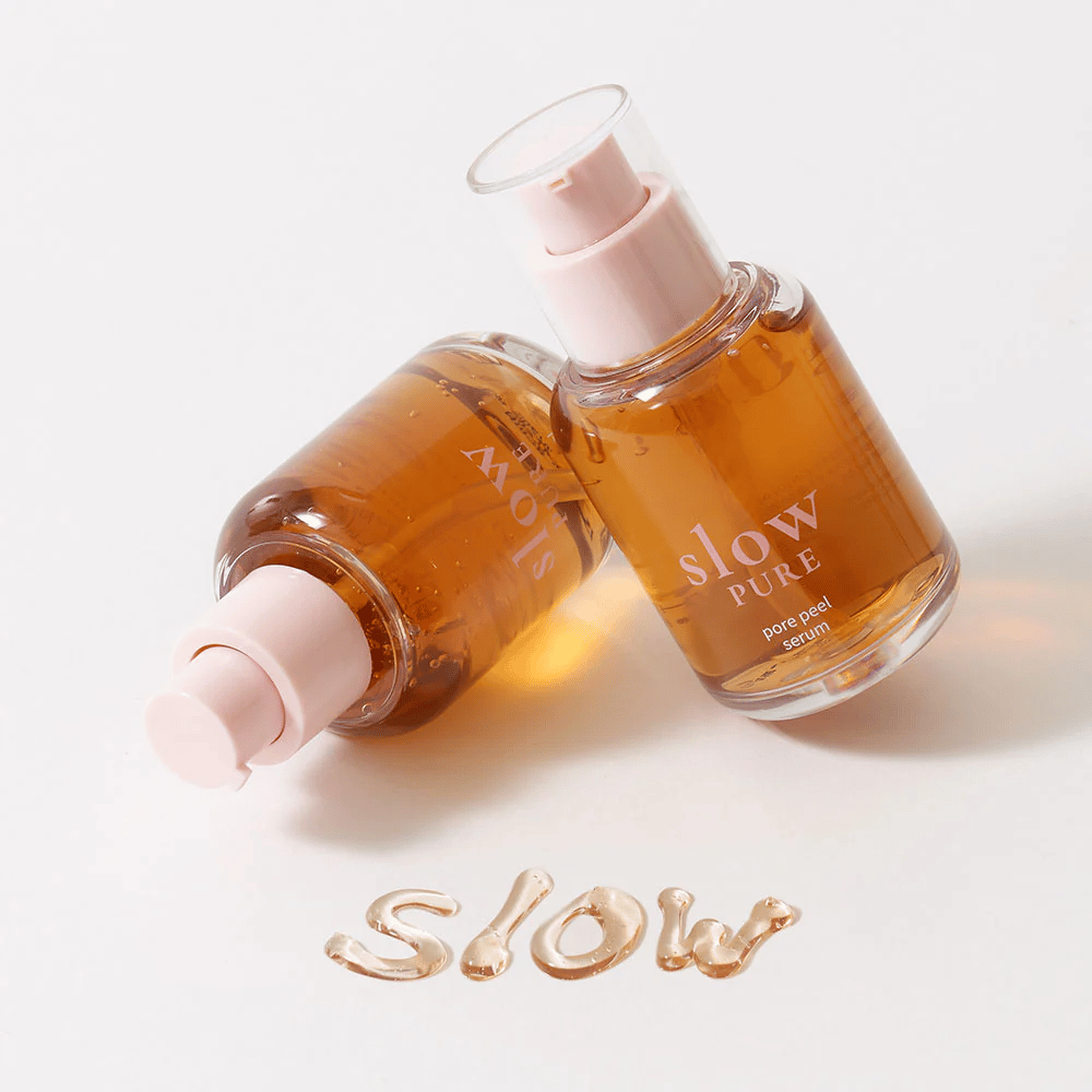 Kaksi Slow Pure Pore Peel Serum pulloa pumpulla, teksti kirjoitettuna seerumilla pinnalle: "Slow".