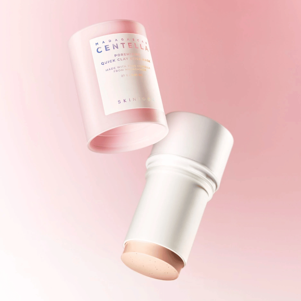 SKIN1004 Madagascar Centella Poremizing Quick Clay Stick Mask elegantissa vaaleanpunaisessa ja valkoisessa muotoilussa. Käytännöllinen puikkomuoto helppoon levitykseen ja syväpuhdistukseen.