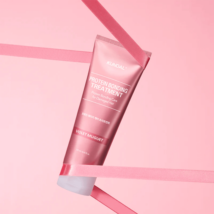 KUNDAL Protein Bonding Treatment Violet Muguet i rosa tub 250 ml mot rosa bakgrund med dekorativa band.