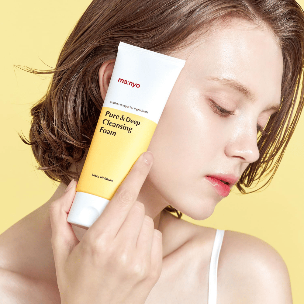Nainen, jolla on terve, kosteutettu iho, pitää Ma:nyo Pure & Deep Cleansing Foam – mieto kasvojenpuhdistusaine, joka antaa hehkua ja tasapainoa luonnollisilla ainesosilla.