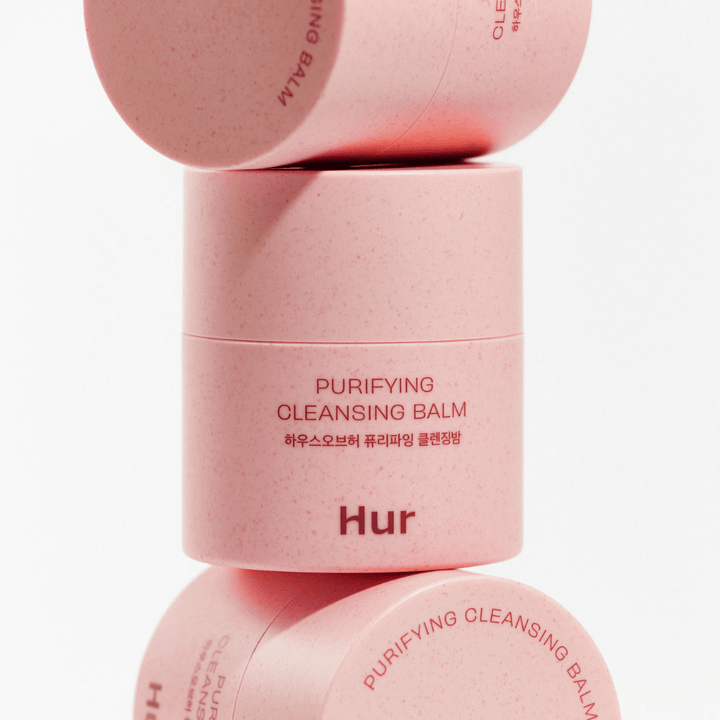 Kuinka Purifying Cleansing Balm vaaleanpunaisessa pakkauksessa pinottuna studiossa. Puhdistava puhdistusbalmi, joka liuottaa tehokkaasti meikin, talin ja epäpuhtaudet kuivattamatta ihoa.