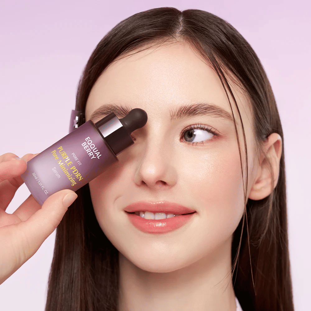 Nuori nainen, jolla on sileä iho, pitää Equal-pulloa Berry Purple PDRN Pore Minimizing Serum otsaansa vasten vaaleanviolettia taustaa vasten.