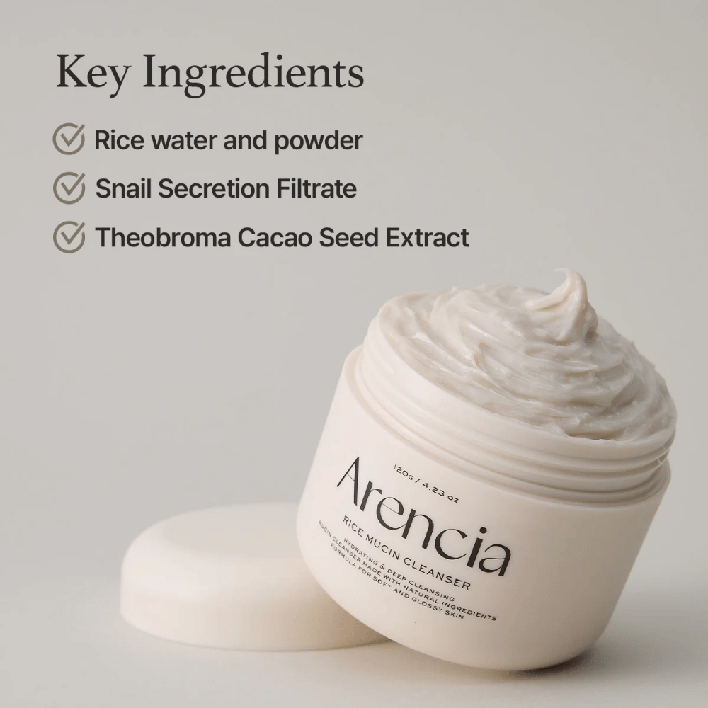 Purkki Arencia Rice Mucin Cleanser, avoin ja täynnä kermaista, valkoista puhdistusainetta. Teksti listaa avainainesosat: riisivesi ja -jauhe, etanaseerumifiltraatti sekä kaakaonsiemenuute.