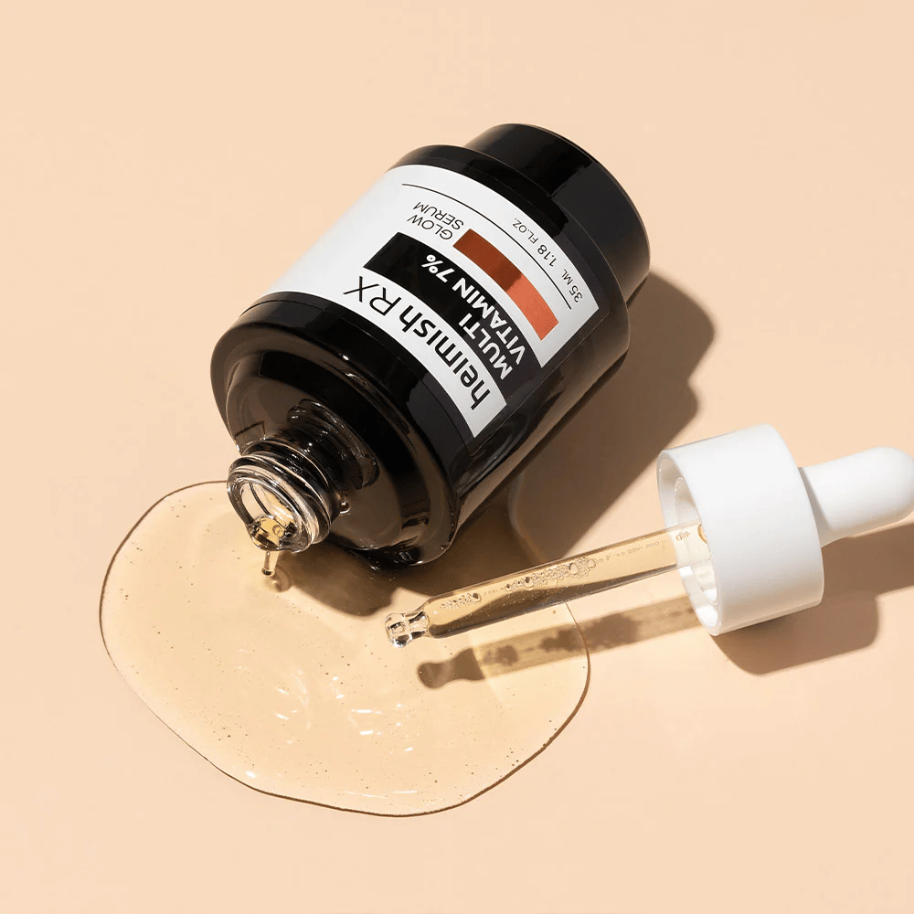 Heimish RX Multi Vitamin 7% Glow Serum makaa beige taustalla, jossa seerumi on levitetty pullon ympärille ja pipetti täytetty tuotteella, korostaen sen ravinnerikasta koostumusta.
