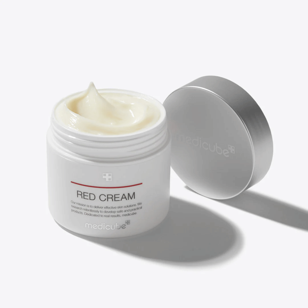 Avoin purkki medicube Red Cream 50ml – vaaleankeltainen kasvovoide valkoisessa pakkauksessa hopeisella kannella, kehitetty aknealtista ihoa varten.