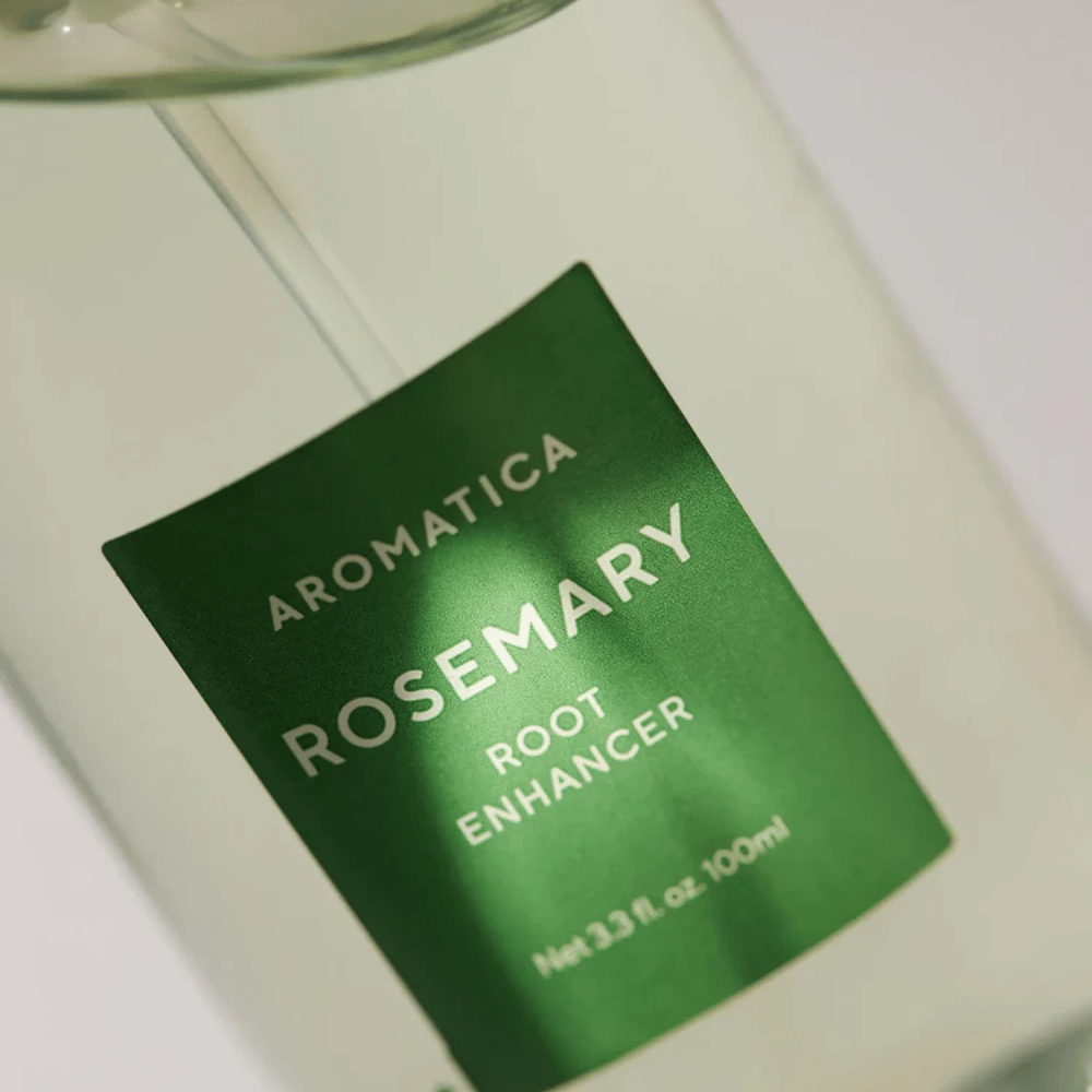 Yksityiskohtainen kuva AROMATICA Rosemary Root Enhancer -tuotteen etiketistä. Vihreä etiketti ja läpinäkyvä pullo korostavat tuotteen puhdasta ja minimalistista ulkonäköä.