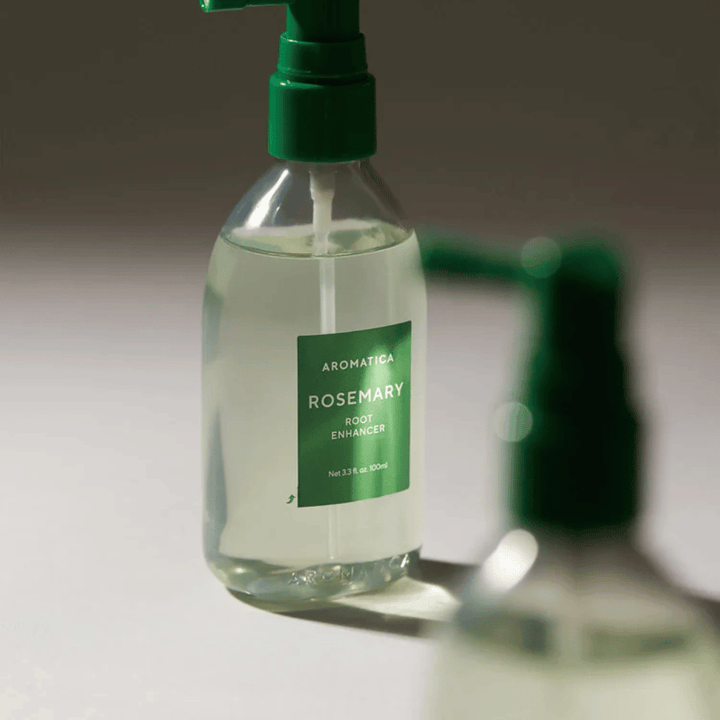 Lähikuva AROMATICA Rosemary Root Enhancer vihreällä annostelukärjellä. Kuva keskittyy pullon muotoiluun ja tarkkaan levitykseen suoraan hiuspohjaan.