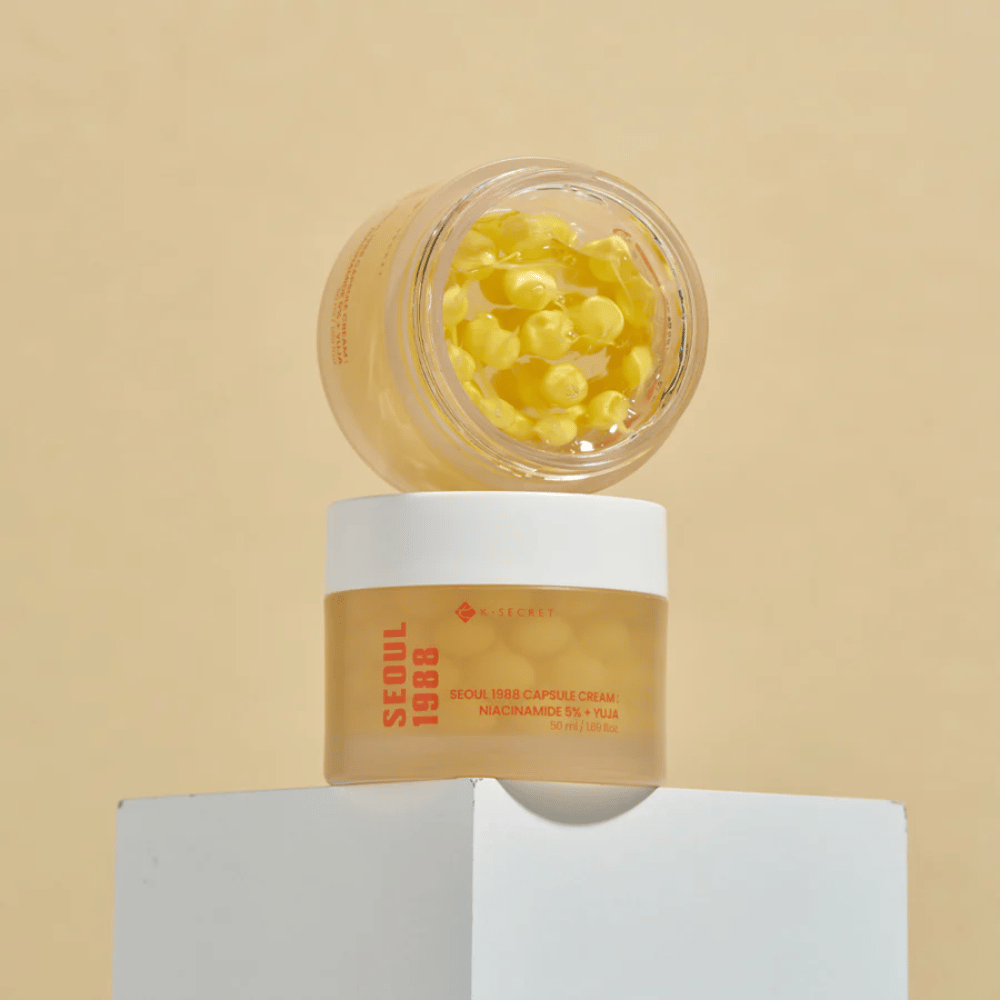 Tyylikäs asettelu: Kaksi purkkia Seoul 1988 Capsule Cream, yksi avoin ja yksi suljettu, asetettuna beigeä taustaa vasten.