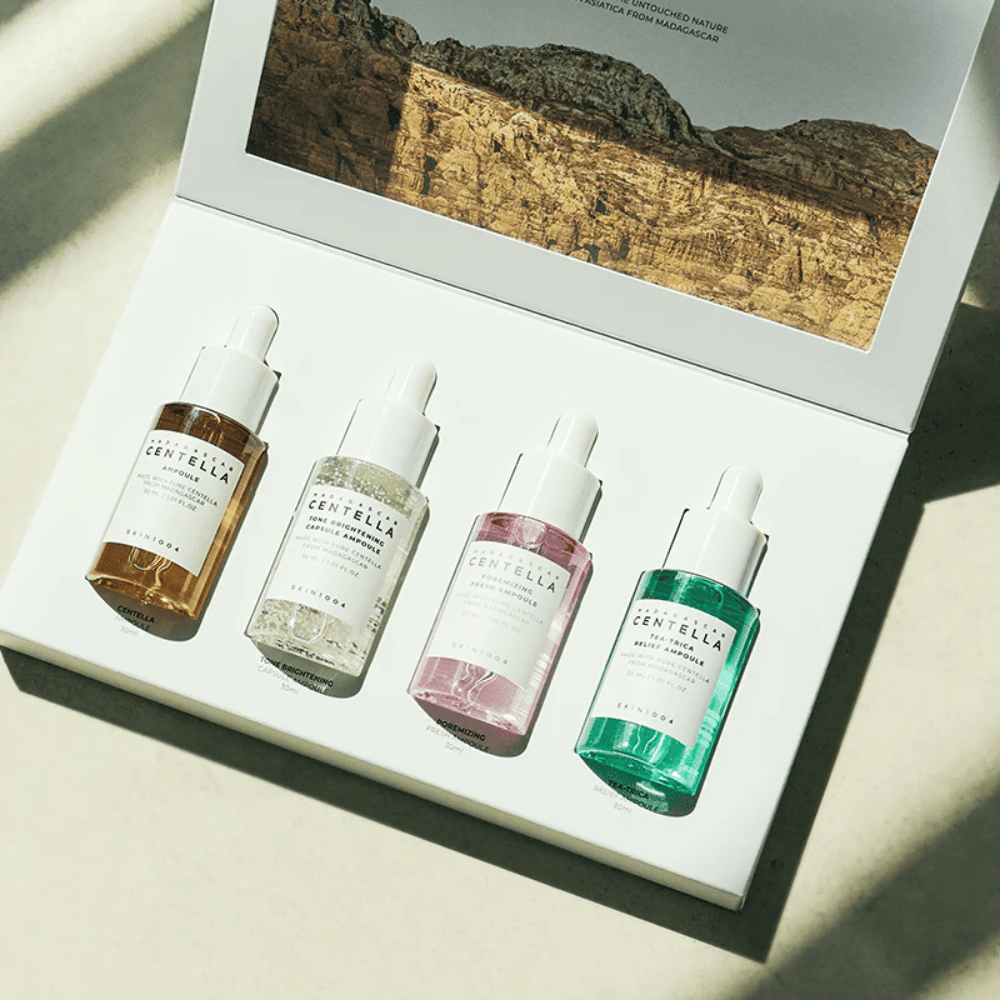 Laatikko, joka sisältää Madagascar Centella Ampoule Kit SKIN1004:sta, sisältää kolme erilaista ihonhoitotuotetta kosteutukseen ja kosteutukseen.