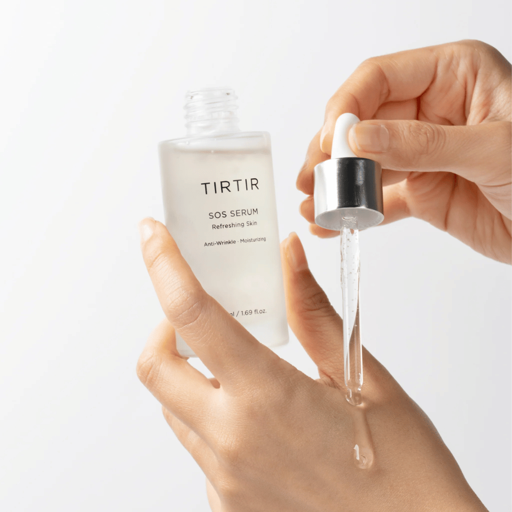 Kädet tiputtavat TIRTIR SOS Serum pipetistä, tarkoitettu ihonhoitoon.