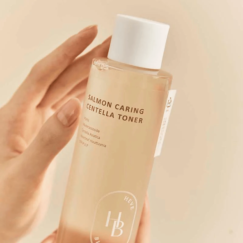 Lähikuva Salmon Caring Centella Toner kädessä – rauhoittava kasvovesi, jossa on PDRN ja kasviuutteita, jotka auttavat vahvistamaan ihoa ja vähentämään ärsytyksen tunnetta.