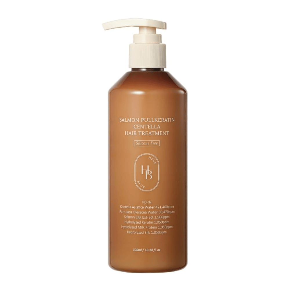 Heveblue Salmon Pullkeratin Centella Hair Treatment ruskeassa pumppupullossa vaaleaa taustaa vasten. Hiushoito, joka sisältää centellaa, lohiuutetta, keratiinia, silkkiproteiinia ja maitoproteiinia hiusten hoitoon ja kosteutukseen.