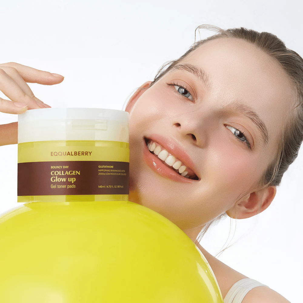 Hymyilevä malli, joka pitää kädessään Bouncy Day Collagen Glow up Gel Toner Pads, joka auttaa antamaan nuorekasta hehkua ja kiinteyttä matalamolekyylisen kollageenin ja glutationin avulla.