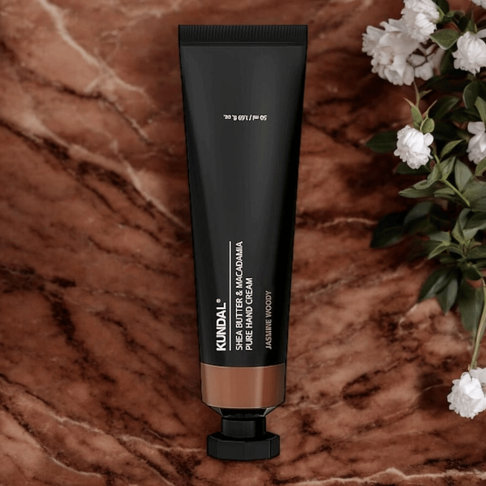 KUNDAL Shea Butter & Macadamia Pure Hand Cream Jasmine Woody marmorilla kukkien kanssa – ravitseva käsivoide, joka hoitaa kuivia käsiä ja antaa elegantin jasmine woody -tuoksun.