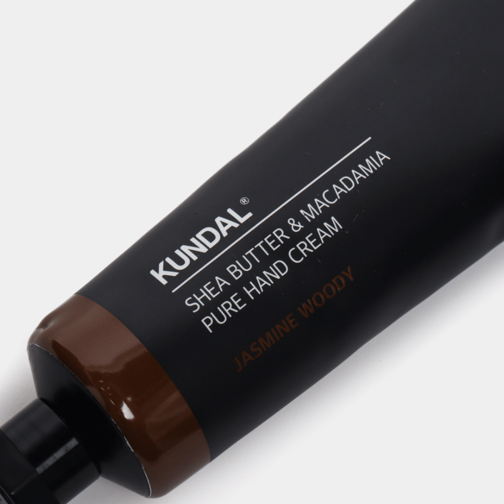 Lähikuva KUNDAL Shea Butter & Macadamia Pure Hand Cream Jasmine Woody joka näyttää tyylikkään pakkauksen ja käsivoiteen premium-tunteen.