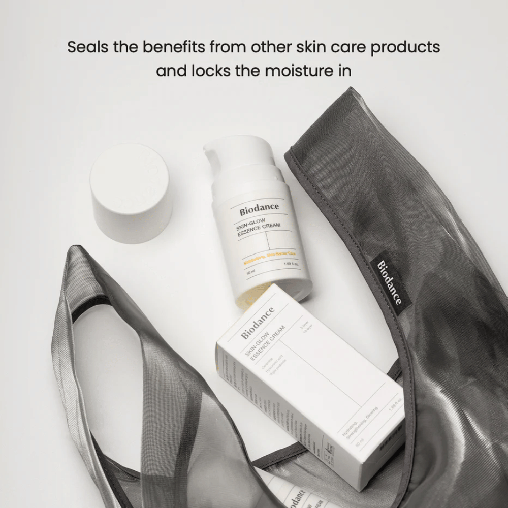 Biodance Skin-Glow Essence Cream keskipisteessä yhdessä tuotepakkauksen ja mustan läpinäkyvän toilettilaukun kanssa, yläpuolella oleva teksti korostaa voiteen kykyä sitoa kosteutta ja tehostaa muiden ihonhoitotuotteiden vaikutusta.
