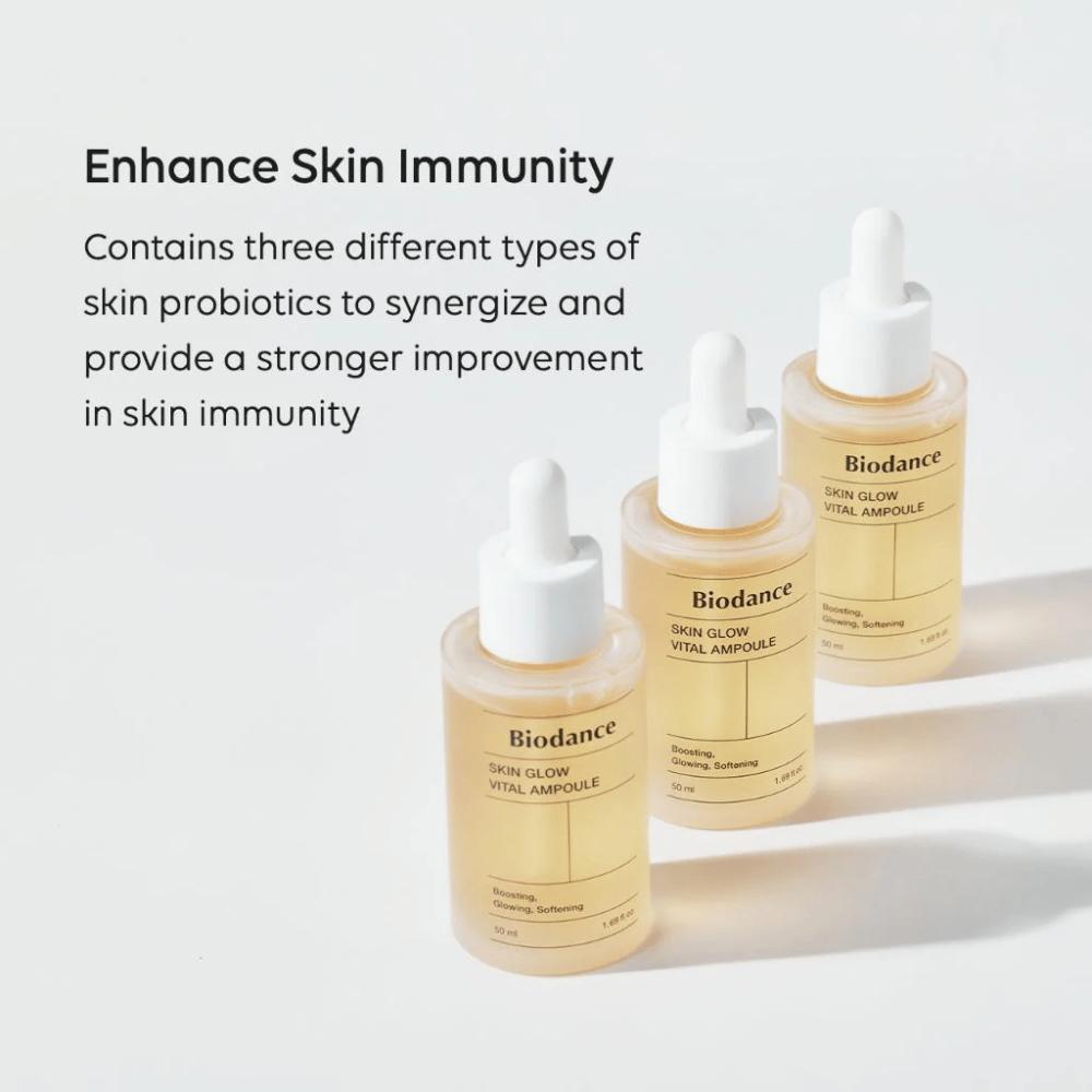 Kolme pulloa Biodance Skin Glow Vital Ampoule näkyy tekstillä 'Enhance Skin Immunity'. Tuote sisältää kolme erilaista ihon probioottia, jotka vahvistavat ihon immuniteettia ja parantavat sen suojaa.