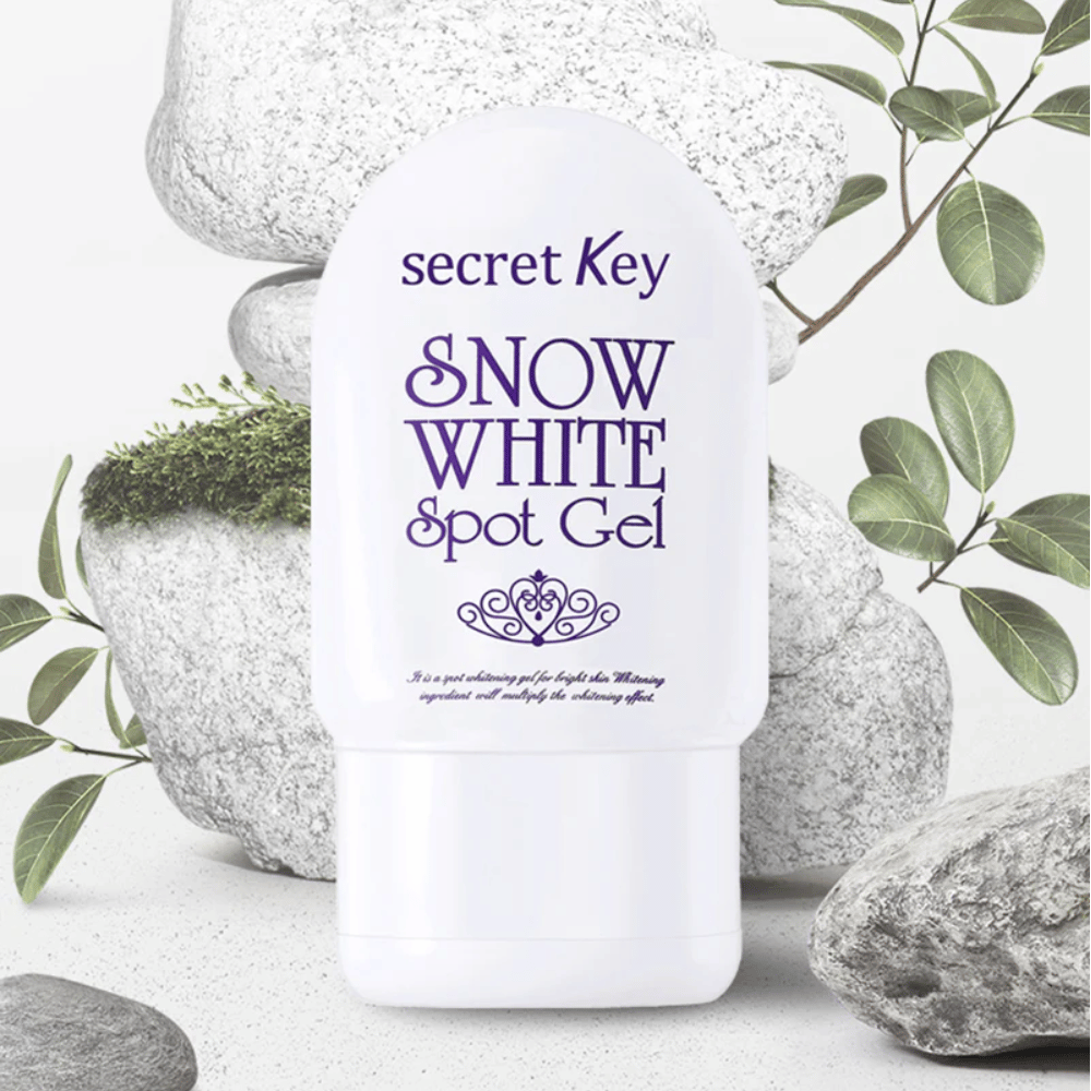 Secret Key Snow White Spot Gel kuvattu kiviä ja vihreitä lehtiä vasten.