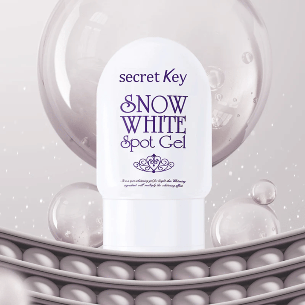 Secret Key Snow White Spot Gel valkoisessa pakkauksessa taustalla kuplia ja helmenkaltaisia yksityiskohtia.