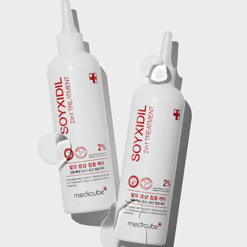 Kaksi pulloa Medicube Soyxidil 2in1 Treatment selkeällä tekstillä ”2% SoyAct™ Solution”. Hoitava käsittely hiustenlähtöä ja kuivaa hiuspohjaa vastaan.