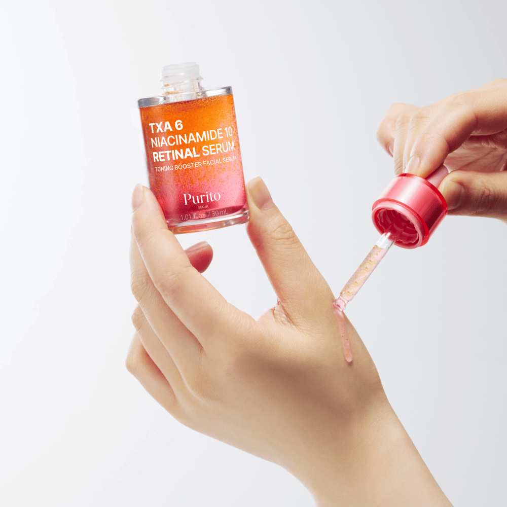 Käsi levittää Purito TXA 6 Niacinamide 10 Retinal Serum. Kevyt koostumus aktiivisilla ainesosilla hehkua, elastisuutta ja kirkkaampaa ihoa varten.