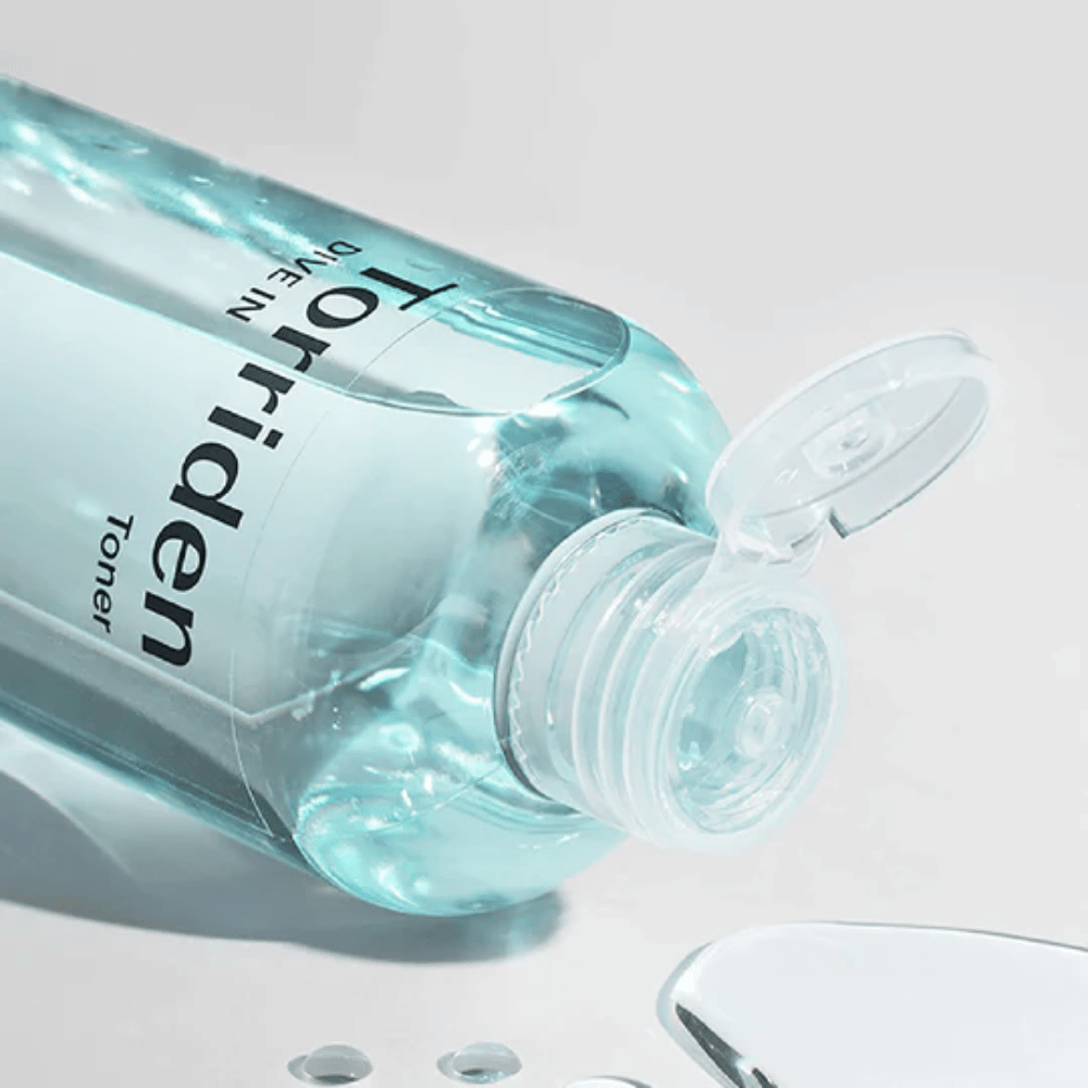 Pullo DIVE-IN Low Molecule Hyaluronic Acid Toner 300ml vesilasin vieressä, edistää Torriden ja kosteutusta.