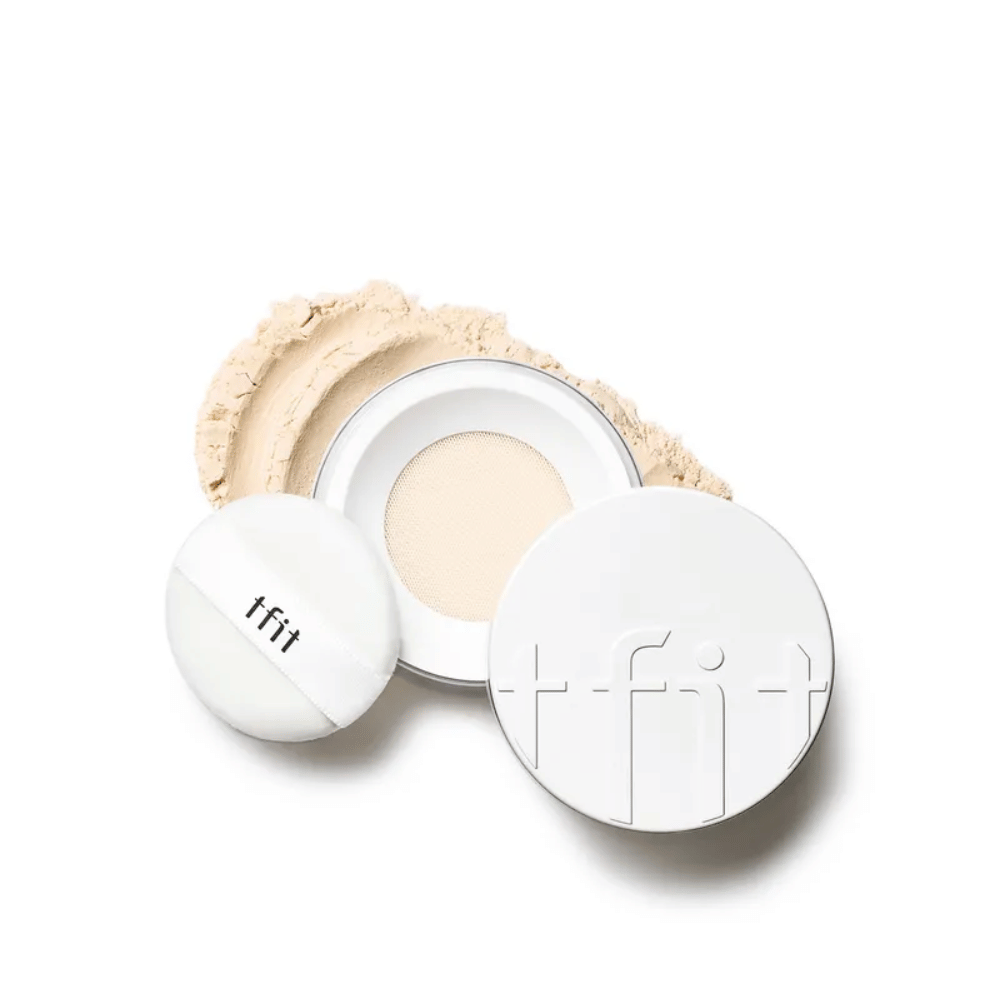 Avoin rasia, jossa on TFIT Translucent Set Finishing Powder sävyssä Skin Beige, mukana puffi ja puuteri ripoteltuna ympäriinsä.