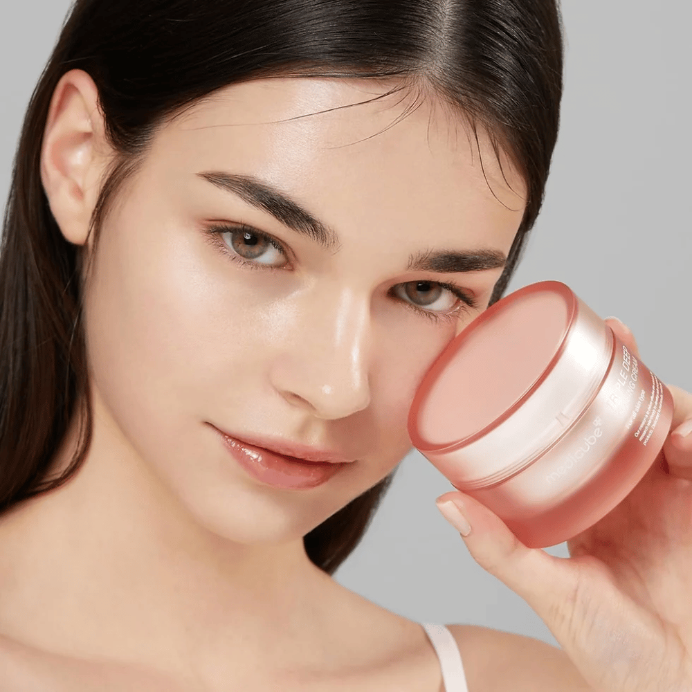 Kuva näyttää naisen, joka pitää kädessään purkkia Triple Collagen Cream. Voide on suunniteltu parantamaan ihon elastisuutta ja kosteutusta. Naisen iho näyttää sileältä ja hyvin hoidetulta.




