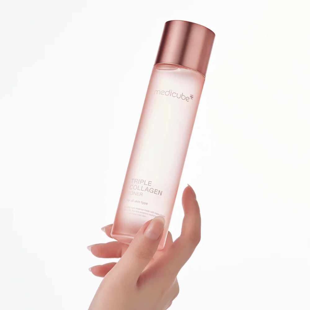 Käsi pitelee vaaleanpunaista pulloa Medicube Triple Collagen Toner 4.0, kosteuttava ja kiinteyttävä kasvovesi kaikille ihotyypeille.