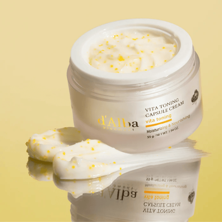 d’Alba Vita Toning Capsule Cream koostumus – kasvovoide, jossa on valkoisia kapseleita, jotka sulautuvat ihoon ja auttavat kosteuttamaan sekä antamaan kirkkaamman ihon sävyn.