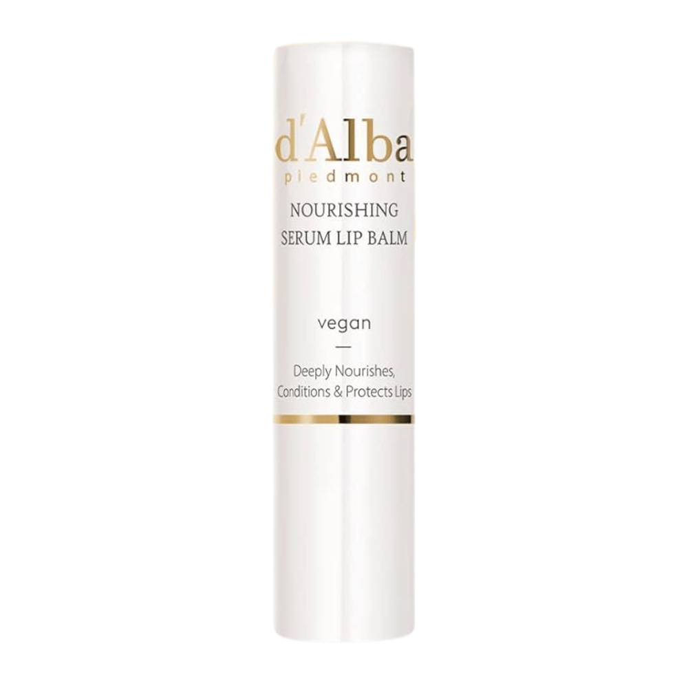Produktbild på d'Alba Nourishing Serum Lip Balm valkoisessa ja kultaisessa pakkauksessa tekstillä "vegaaninen" ja "Syvästi ravitsee, hoitaa & suojaa huulia".