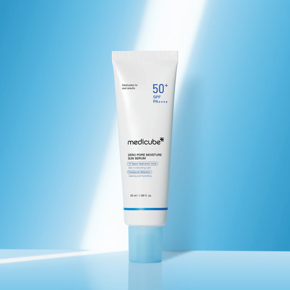 Medicube Zero Pore Moisture Sun Serum SPF50+ PA++++ esitettynä sinistä taustaa vasten. Kosteuttava aurinkoseerumi, jossa on hyaluronihappoa, pantenolia ja allantoiinia päivittäiseen UV-suojaan ja ihon hoitoon.