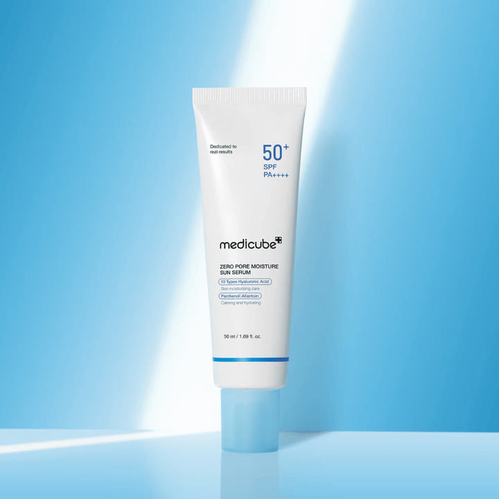 Medicube Zero Pore Moisture Sun Serum SPF50+ PA++++ esitettynä sinistä taustaa vasten. Kosteuttava aurinkoseerumi, jossa on hyaluronihappoa, pantenolia ja allantoiinia päivittäiseen UV-suojaan ja ihon hoitoon.