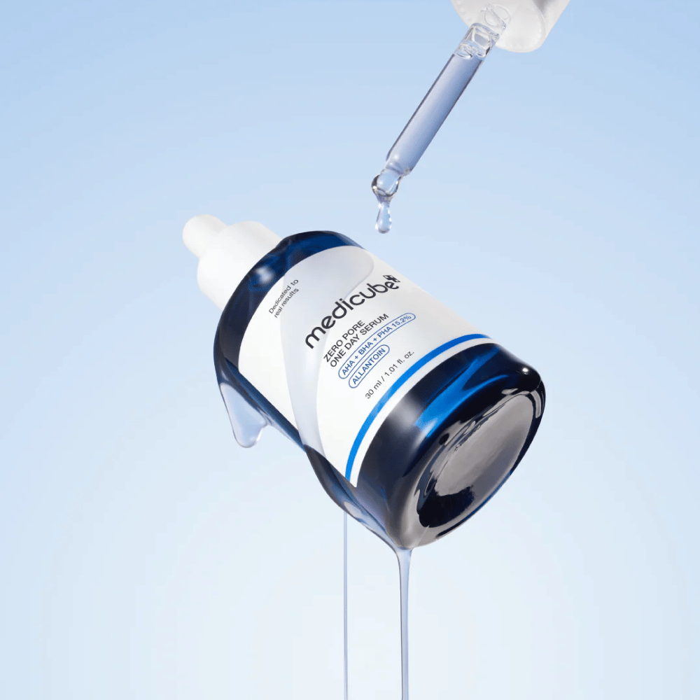 Pullo Medicube Zero Pore One Day Serum pipetillä ja valuvilla seerumitipoilla vaaleansinisellä taustalla.
