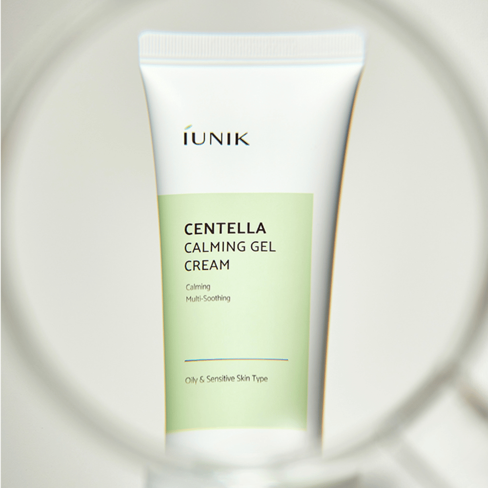 Putkilo iUNIK Centella Calming Gel Cream valkoisella ja vaaleanvihreällä designilla seisoo pystyssä, nähtynä pyöreän suurennuslasimaisen kehyksen läpi.