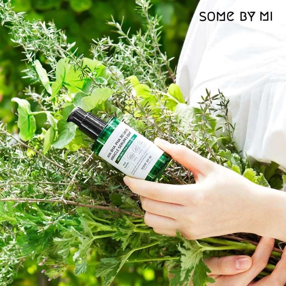 Nainen, joka pitää käsissään joukkoa yrttejä pigmenttiläiskien ja aknen ehkäisemiseksi käyttäen AHA, BHA, PHA 30 Days Miracle Serum Light 50ml SOME BY MI:stä.