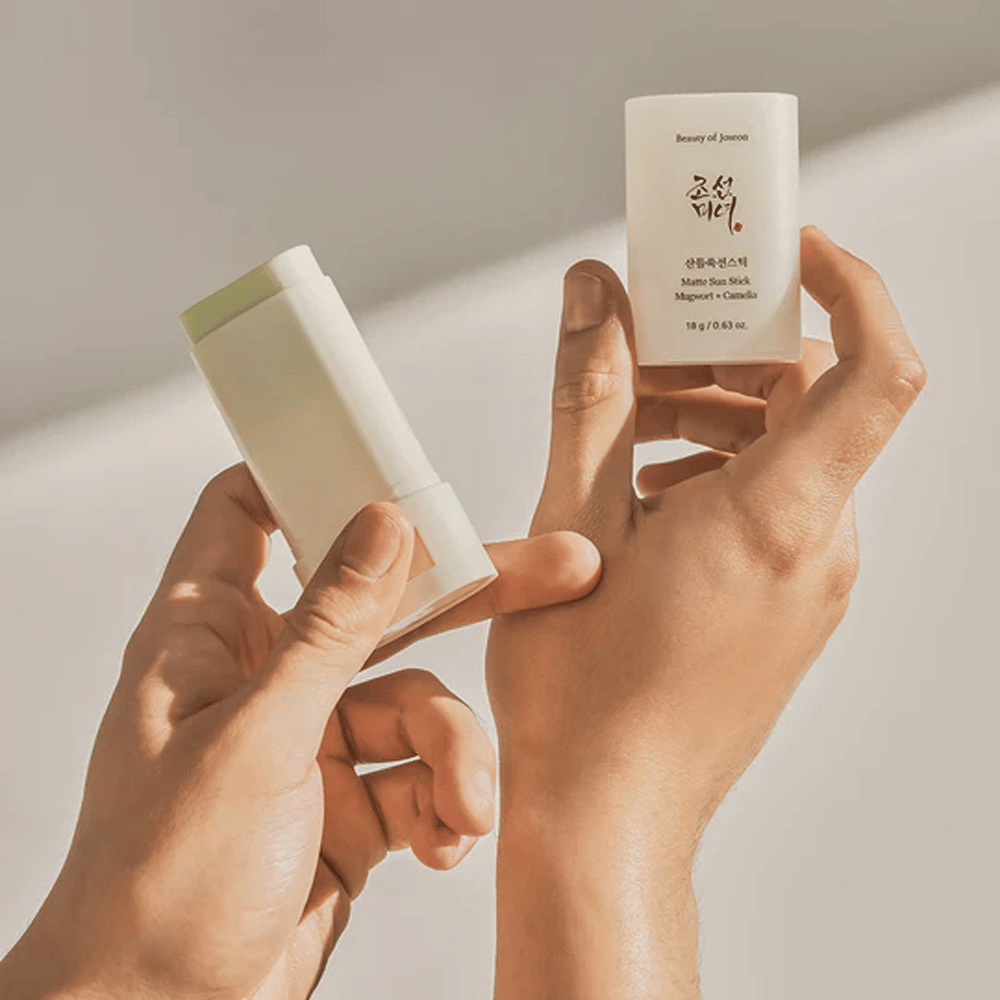 Kaksi kättä, jotka pitävät Beauty of Joseon'n Matte Sun Stick 18g SPF50 PA++++.