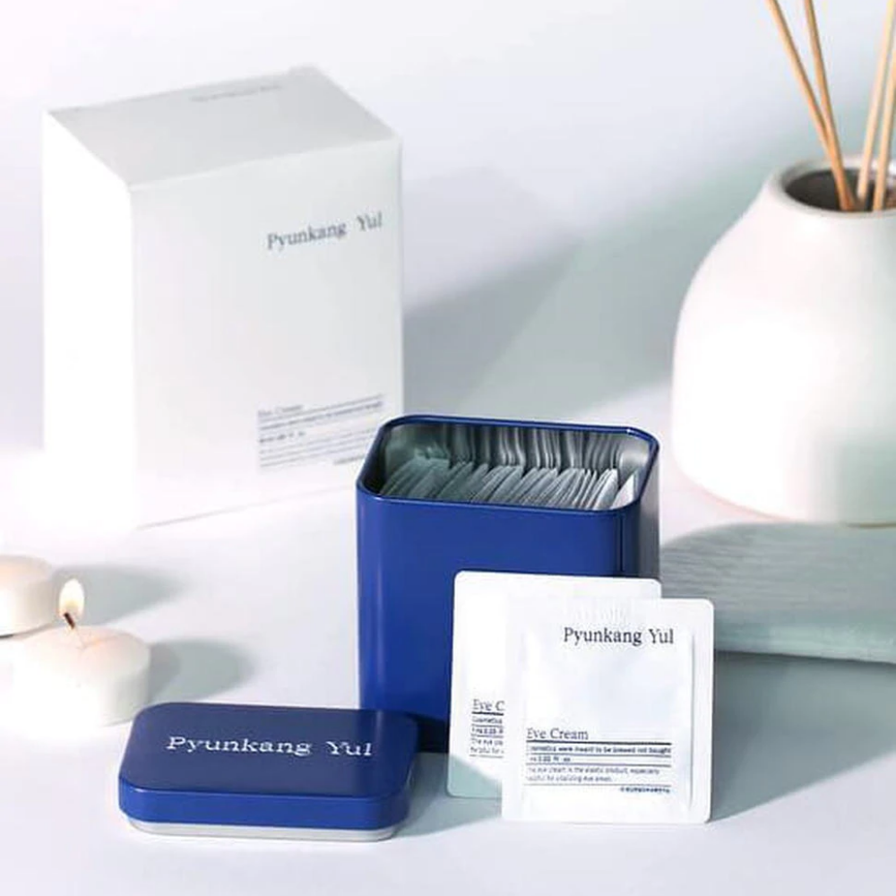 Valkoinen laatikko, jossa on sininen kansi ja Pyunkang Yul Eye Cream 1ml x 50kpl vieressä.